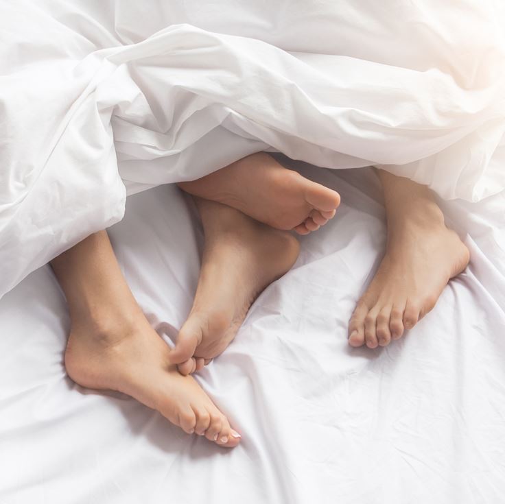 Sexual Wellness Advice | Couples' Feet Coming Out Under Blanket | Bodyjoys